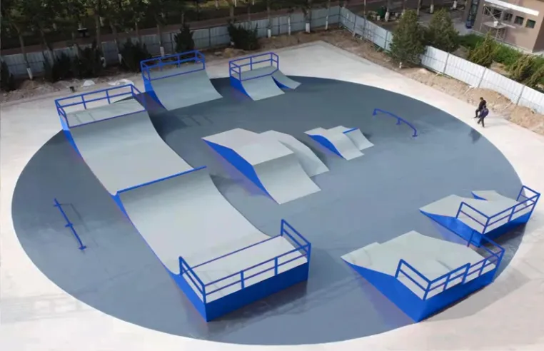 Circular skatepark pad with blue steel-framed ramps and rails