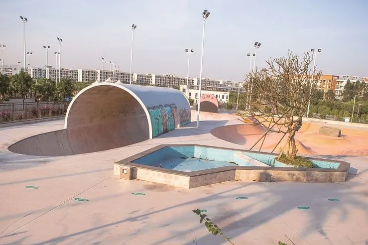Large concrete skatepark with a full pipe and bowls